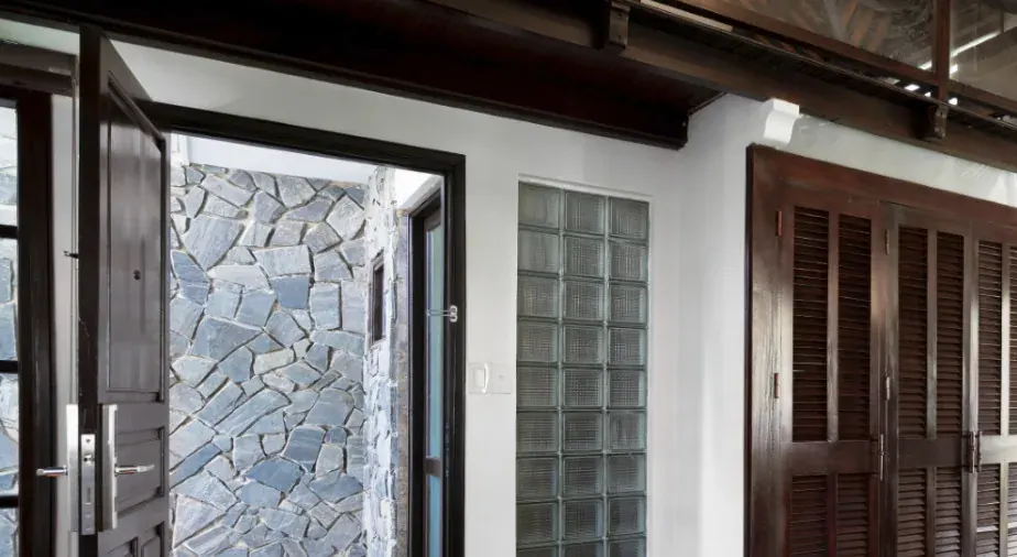 Una puerta abierta al patio de laja, con el paño de pavés y las contraventanas de madera