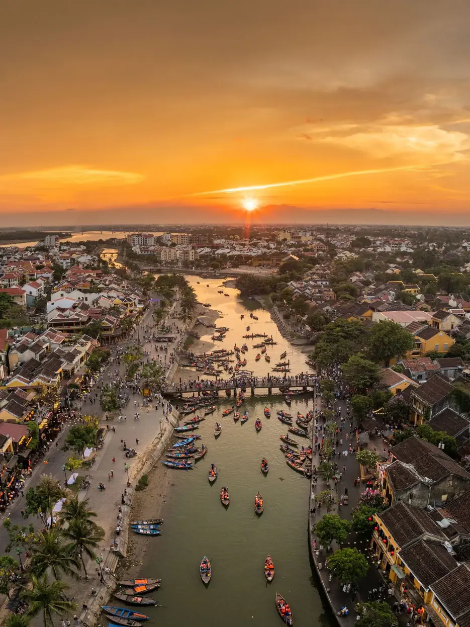 Aerial view of Hoi An at sunset, with the river, the boats and the tiled blocks