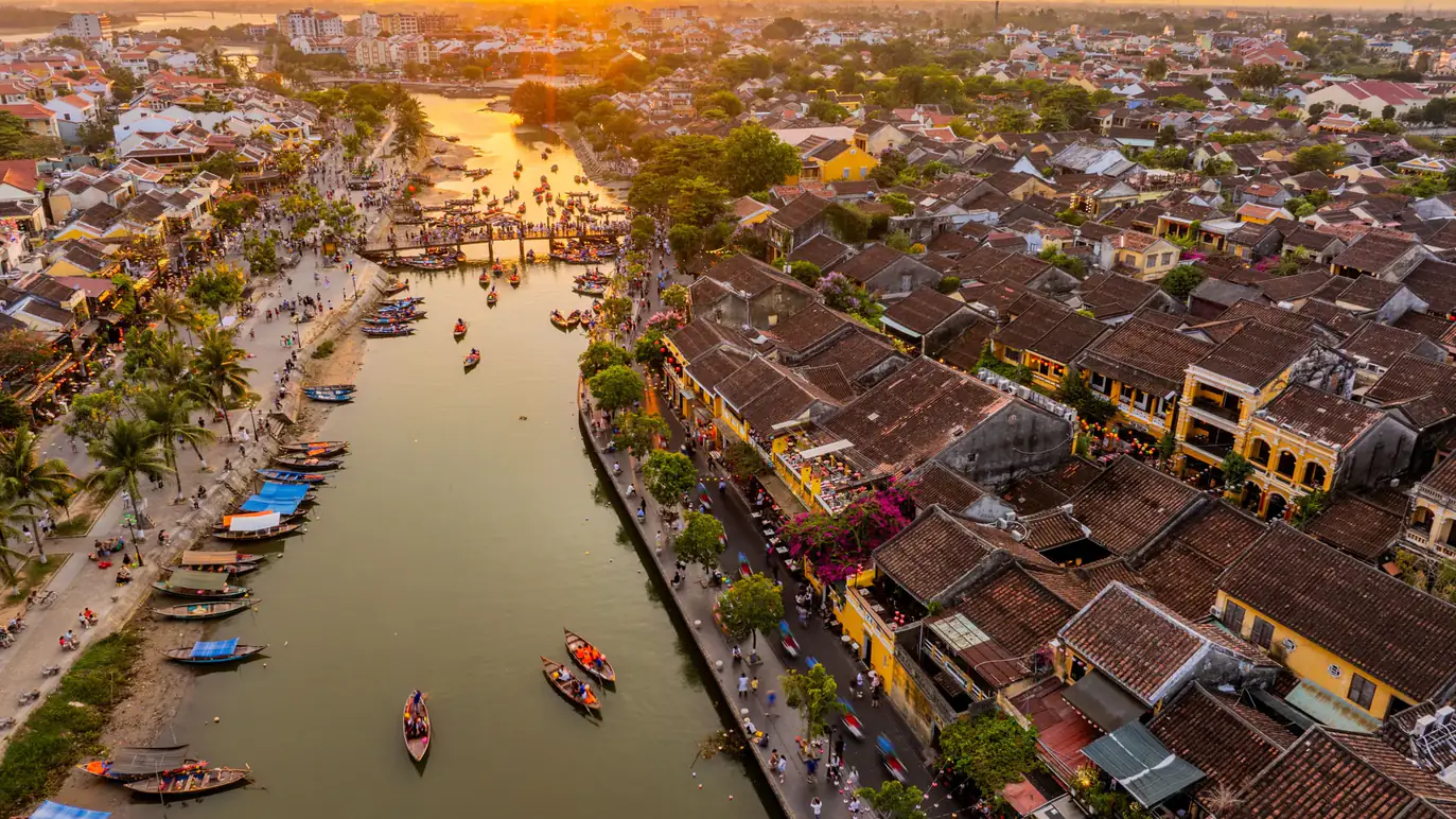Hội An from the air at sunset: the old town roofs and the river full of boats