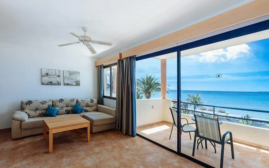 Salón de un apartamento del Royal Mónica abierto de suelo a techo a la terraza sobre el Atlántico