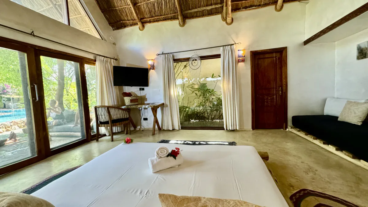 Dormitorio de una Poolside Villa del Nest: la cama king frente a las puertas abiertas a la piscina