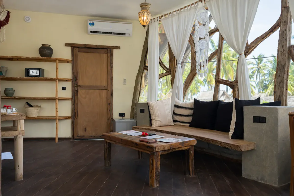 The Tree House lounge, with the cushioned bench and the low table under the branch-framed window