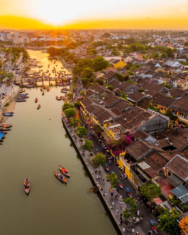The Thu Bồn river running down through Hội An at sunset, rowing boats crossing it