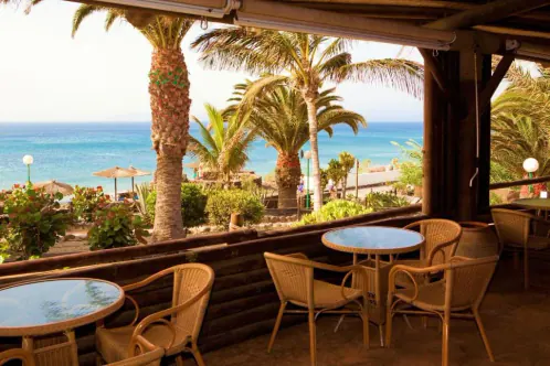 The restaurant terrace under its pergola, tables facing the sea