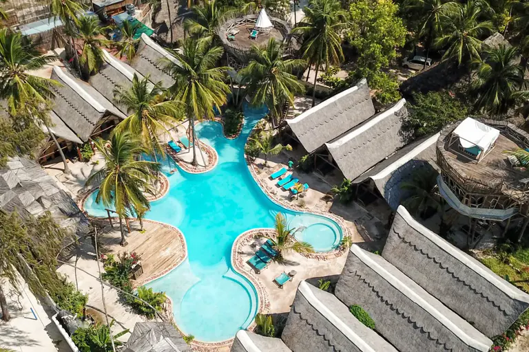 El Nest desde el aire: piscinas sinuosas entre tejados de makuti y cocoteros