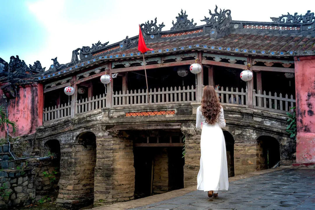 Hội An's Japanese Covered Bridge, with a figure in white áo dài seen from behind